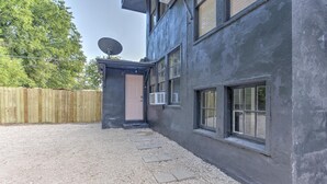 A building with a gravel driveway, a wooden fence, and a satellite dish. - Tiny Trendy Traveler's Studio in Historic Midtown! (Memphis)