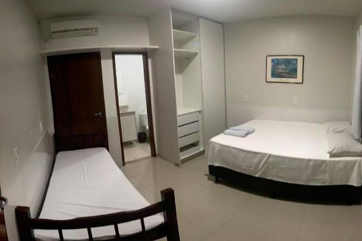 Une chambre à coucher avec un lit, une armoire et un petit bureau.