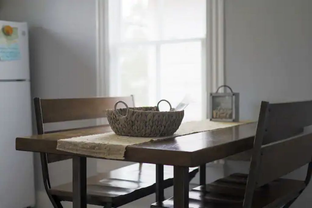 Una mesa de madera con una cesta tejida y un candelabro.
