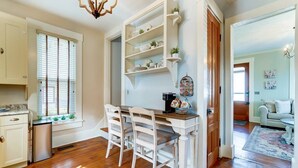 A kitchen with a dining table, white chairs, and a built-in white shelving unit. - Walk to Restaurants & Shops of Downtown Miamisburg (Miamisburg)
