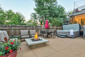Eine Außenpatio mit Feuerstelle, Sitzbereich und Grill.