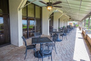 Enjoy meals and conversations in a shaded outdoor space with comfortable seating and dining tables.