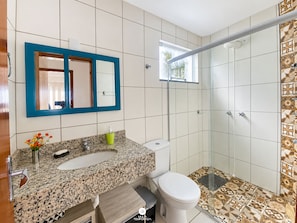 Une salle de bain avec deux éviers, des toilettes et une douche à l’italienne.
