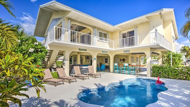 A two-story house with a swimming pool, outdoor seating, and a balcony. - Private Pool, Hot Tub, Boat Dock, Putting Green (Marathon)