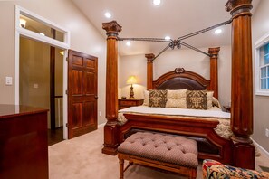 A four-poster bed with a wooden headboard, a bench at the foot of the bed, and a nightstand with a lamp. - This Gives a “Cabin” a Whole New Meaning! (Carbondale)