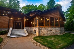 A modern log cabin with a stone foundation, large windows, and a welcoming front porch with steps. - This Gives a “Cabin” a Whole New Meaning! (Carbondale)