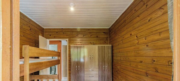 A narrow hallway with wooden walls and a sloped ceiling. - Casa com Piscina em Gov Celso Ramos - SC (Governador Celso Ramos)
