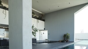 A modern indoor pool area with a reflective floor, large pillars, and potted plants. - Most Luxurious Property in Puebla - Ultra Luxurious 4 Bedrooms 4.5 Bath - Pool (Tx)