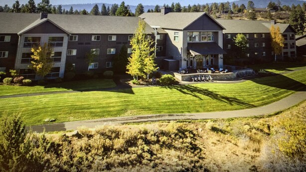 A hotel with multiple buildings, a well-maintained lawn, and a clear view of the surrounding landscape. - Golf resort for Labor Weekend (Klamath Falls)