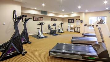 A gym with treadmills, stationary bikes, and an elliptical machine.