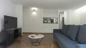 A modern living room with a flat-screen TV, a round coffee table, and a grey sofa. - Balsas By Homirent (Mexico City)