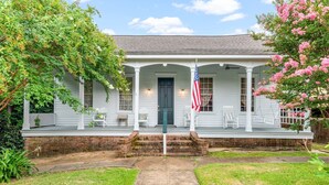 A white house with a porch, a flag, and a brick staircase leading to the door. - 1880's Cozy Cottage, close to Historical Downtown. Sleeps up to 6
3B3B-pets OK (Natchez)