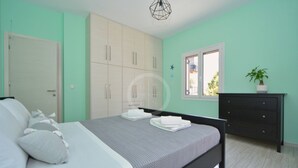 A bedroom with a bed, a dresser, a wardrobe, and a window. - A contemporary inn situated in the center of Ermioni (Ermioni)