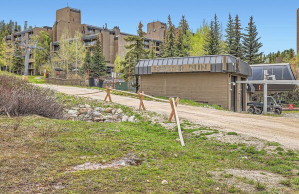 Un edifici amb la taronja "BEAVER RUN", una zona exterior coberta, un camí de terra i arbres al voltant.