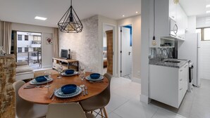 Une cuisine moderne avec des armoires blanches, un comptoir en granit et un four encastré.