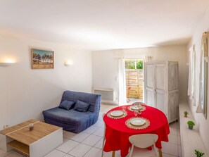 Cozy living space with a seating area, dining table for four, and a door leading to an outdoor area.