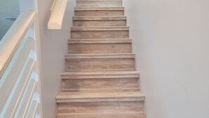 Eine hölzerne Treppe mit weißer Handlauf, die nach oben führt.