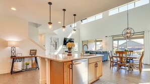 Una cocina amplia con una isla central, armarios de madera e iluminación colgante.