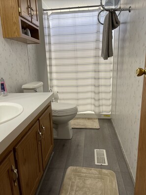 Chuveiro, toalhas de banho, sabonete, shampoo