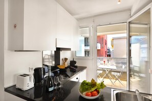 Een moderne keuken met een broodrooster, koffiezetapparaat en wijnglazen op het aanrecht.