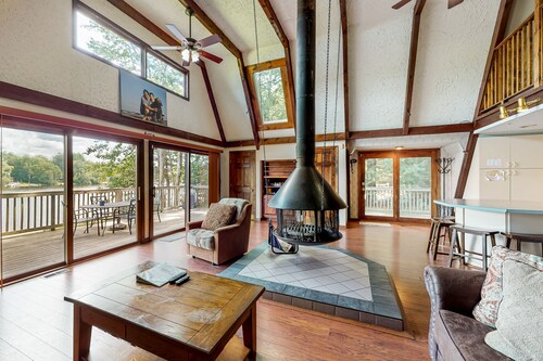 Waterfront home with wraparound deck, floating fireplace, deck, & firepit