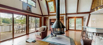 Waterfront home with wraparound deck, floating fireplace, deck, & firepit