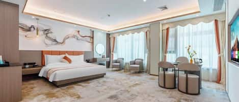 Una habitación de hotel moderna con una cama grande, un escritorio, una silla y un televisor.