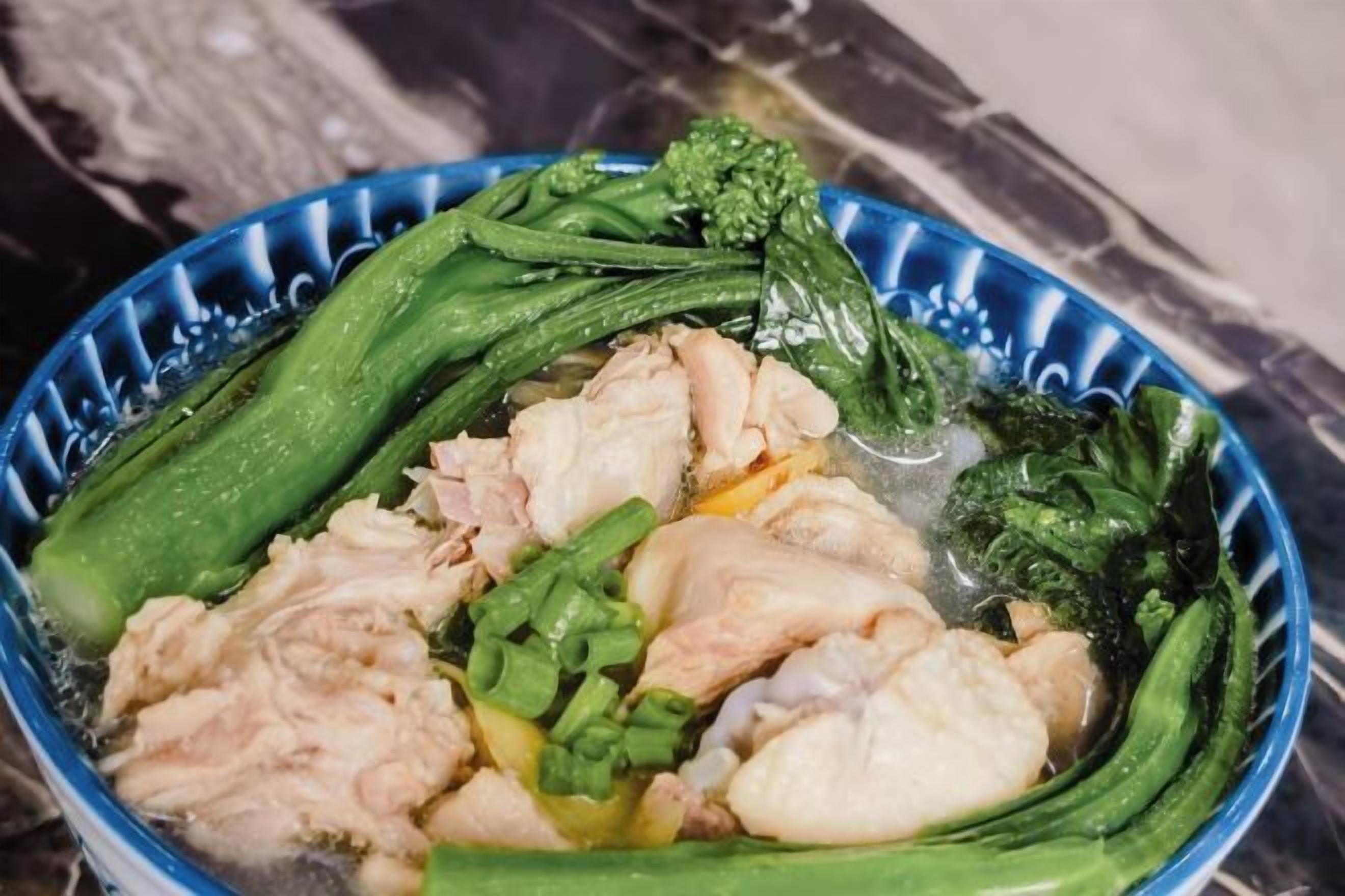 A bowl of soup with vegetables and meat.