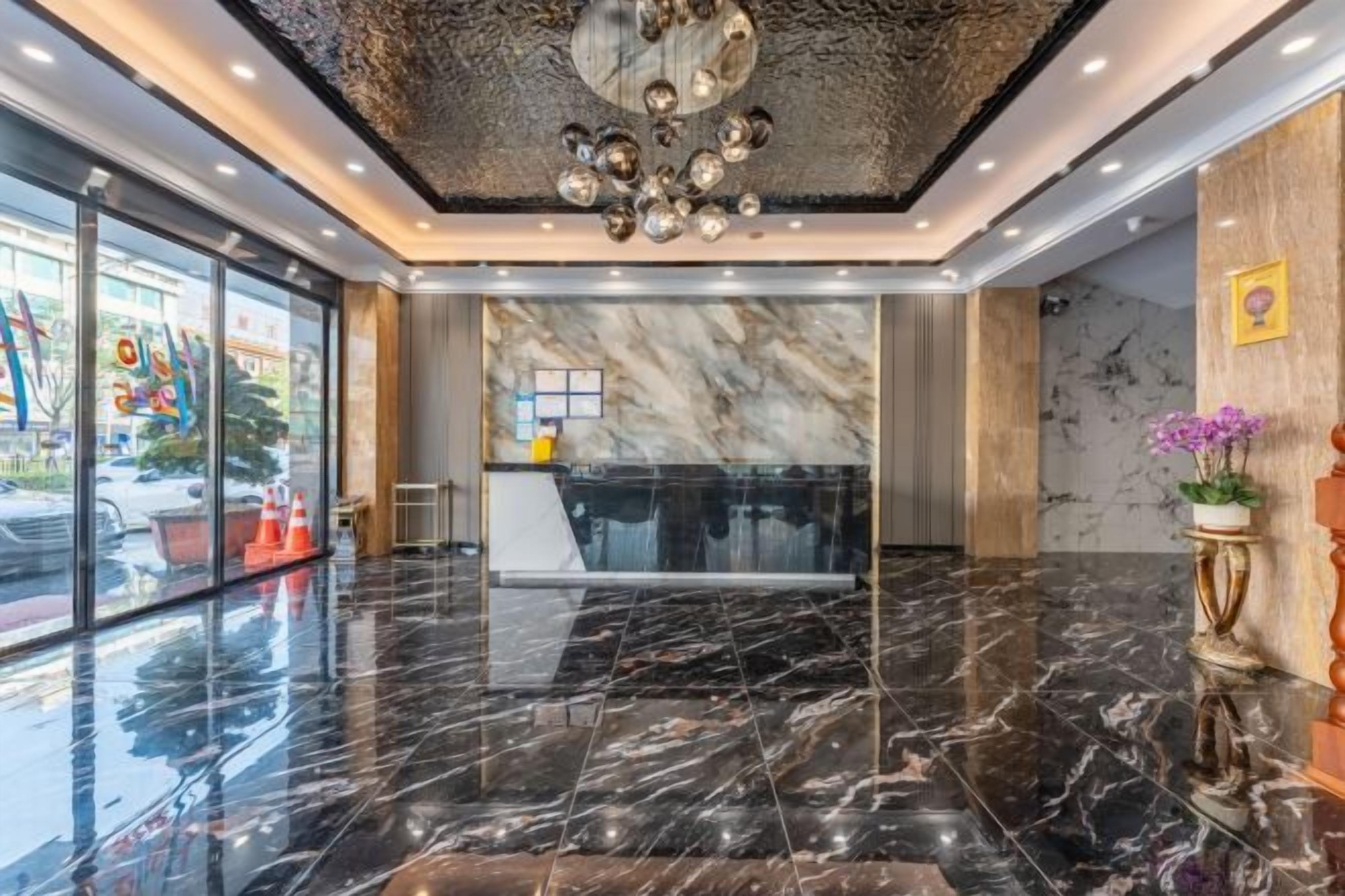 A modern lobby with a marble floor, a reception desk, and a decorative ceiling.