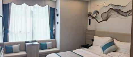 A modern hotel room with a large bed, a seating area with a view, and a decorative wall piece.