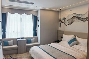 A modern hotel room with a large bed, a seating area with a view, and a decorative wall piece. - Xiangxing Hotel (Zhongshan)