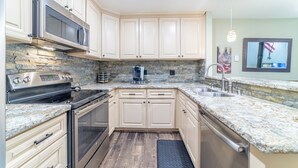 A kitchen with granite countertops, stainless steel appliances, and light-colored cabinetry. - Beautiful St Moritz Family Home 560 (Mammoth Lakes)