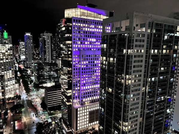 A high-rise building with a grid of windows, surrounded by other tall buildings.