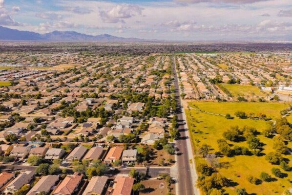 Vista aérea de una zona residencial con casas, una carretera y un campo verde.