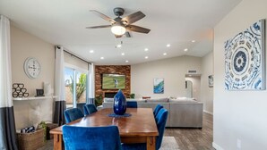 Un comedor con una mesa de madera, sillas azules y un jarrón azul como centro de mesa.