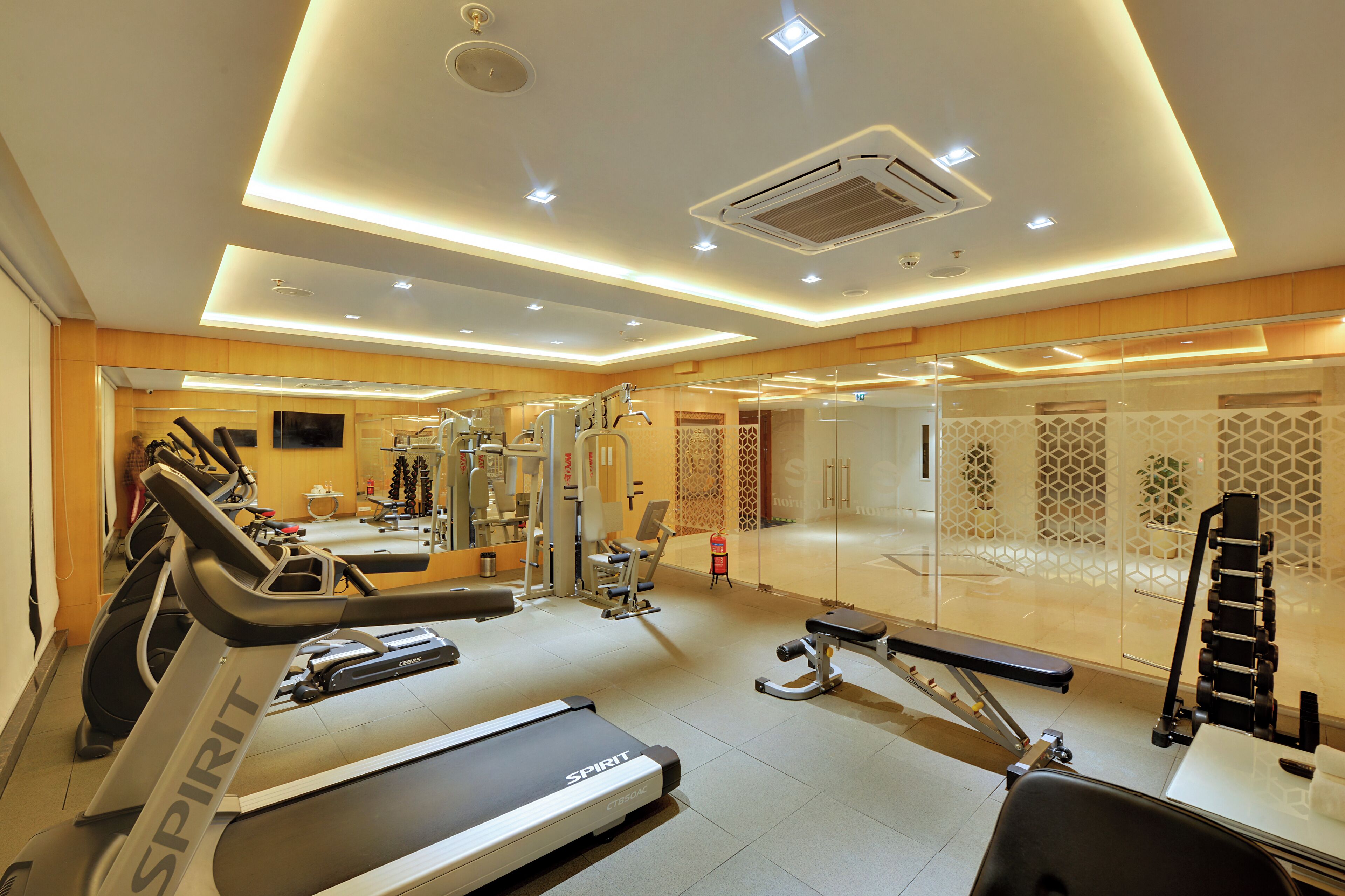 Ein modernes Fitnessstudio mit Laufbändern, Trainingsgeräten und einer Spiegelwand.