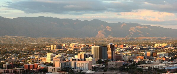 A cityscape with a prominent skyscraper, surrounded by residential buildings and mountains in the background. - Reid Park & Zoo / Golf / 3 BR 2 BA / Remodeled (Tucson)