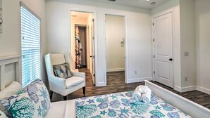 A bedroom with a bed, a chair, and a door leading to a hallway. - Tampa House w/ Patio, Near Downtown & Beaches! (Tampa)