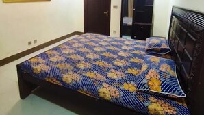 A bedroom with a bed, a door, a wardrobe, and a painting on the wall. - 7K Heights (Mekhtar)