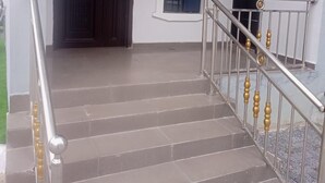 A staircase with a metal railing and a door at the top. - Captivating 1-bed Studio in Sapele (Sapele)