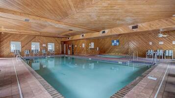 Una piscina interior con paredes de madera y suelo de baldosas.