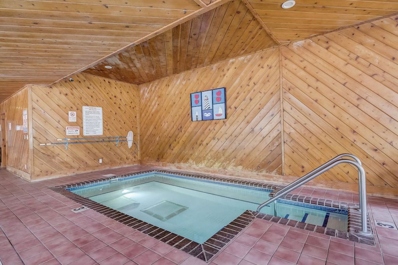 Una piscina interior con paredes de madera y suelo de baldosas.