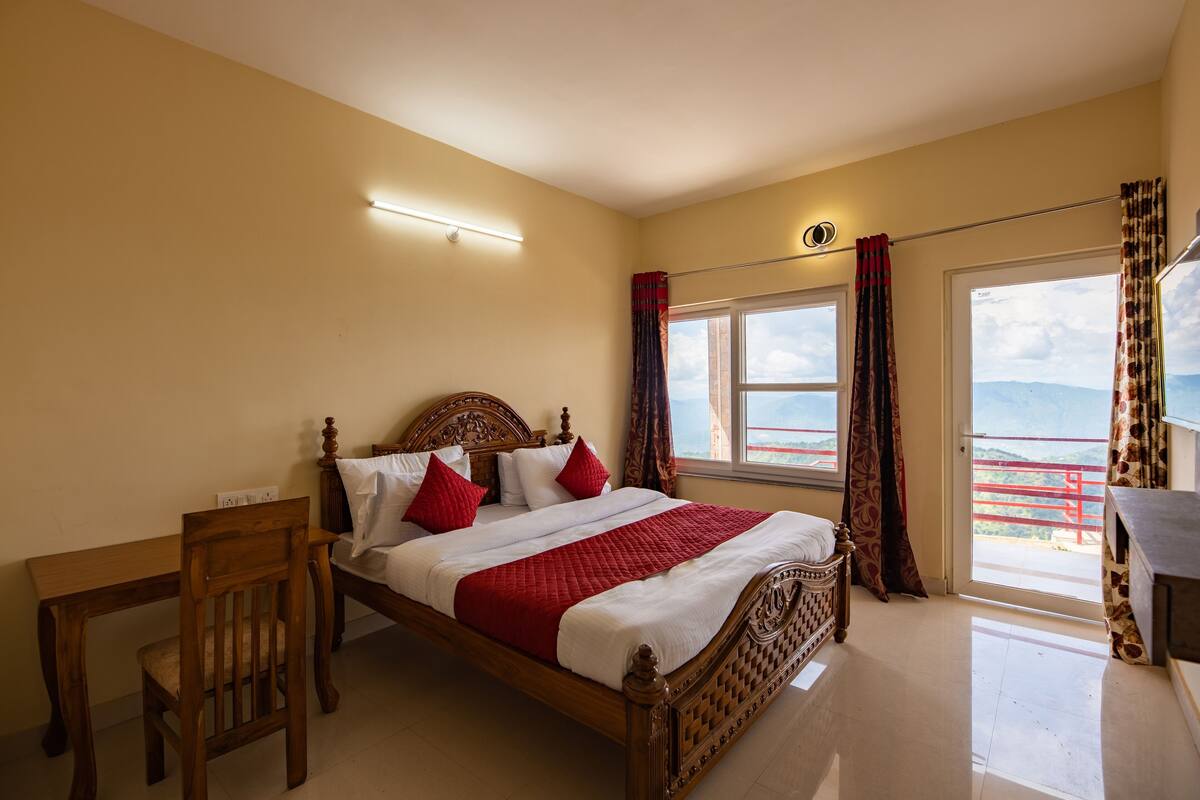 Une chambre à coucher avec un lit en bois, une table de chevet, une chaise, une fenêtre avec des rideaux et une vue sur l’extérieur.