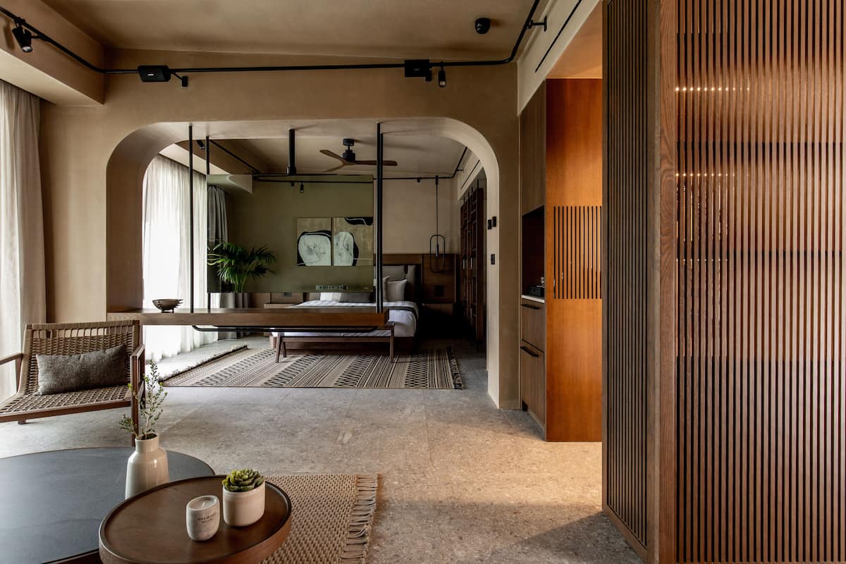 Ein modernes Hotelzimmer mit Bett, Sitzecke und Esstisch.
