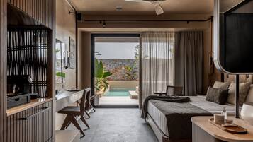 Ein modernes Hotelzimmer mit Bett, Schreibtisch und Stuhl, einem Balkon mit Pool und Blick ins Grüne.