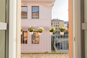 Enjoy the serene view from this balcony overlooking the surrounding buildings.