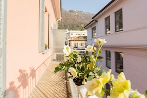 Enjoy a peaceful retreat on this balcony with a potted plant and city views.