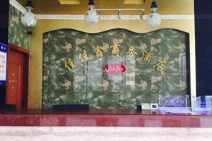 A reception area with a marble counter, a wall with Chinese characters, and a sign that reads 'Yea Jia'. - Gezi Hotel (Keyuan Avenue Branch) (Nanning)