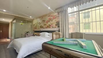 Een hotelkamer met een bed, een groene pooltafel, een decoratieve wand en een raam met gordijnen.