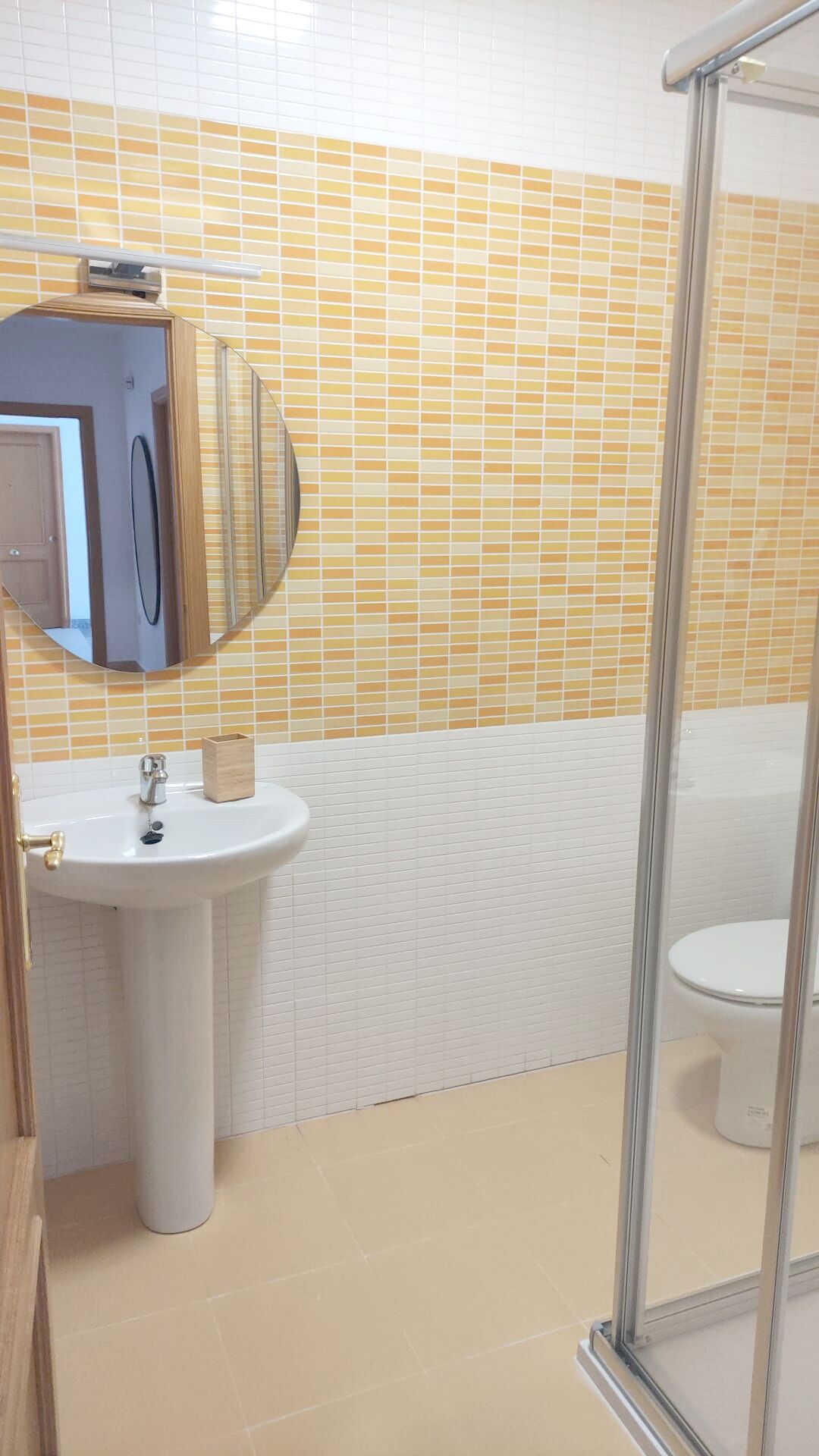 A bathroom with a white sink, a mirror, and a toilet.